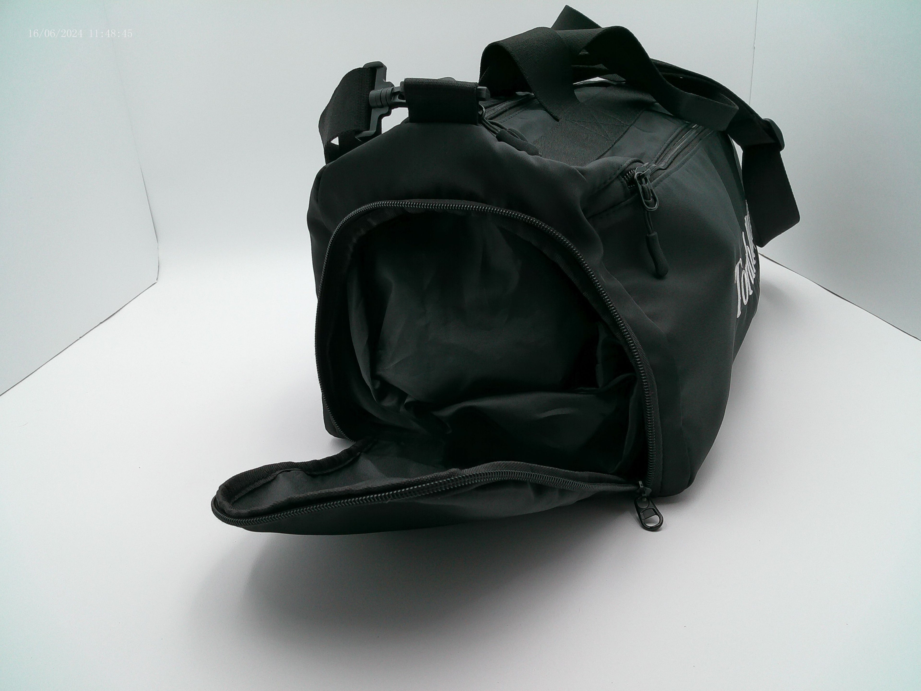 Side view of black duffel bag on a white background